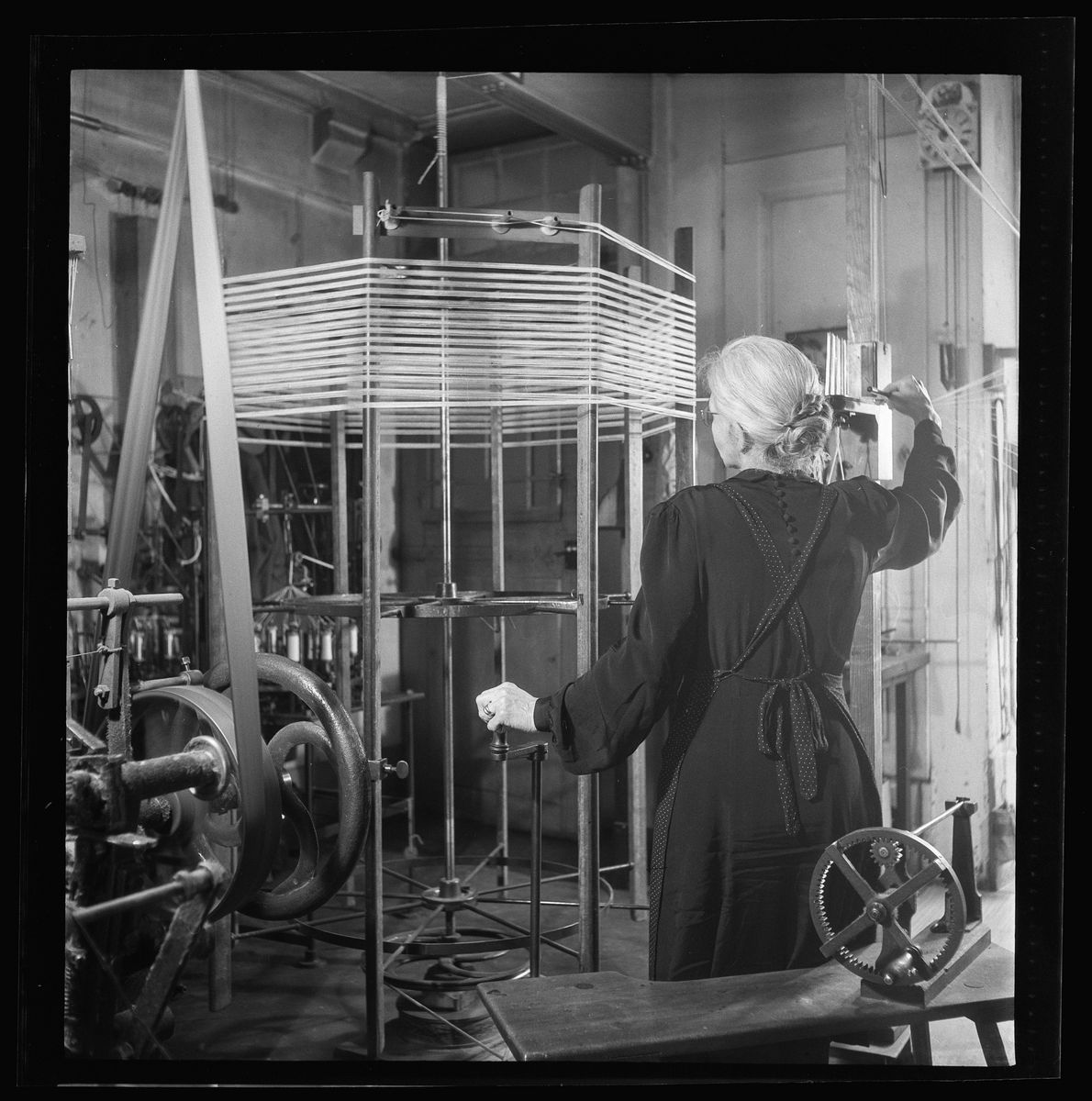 Eine Frau bedient eine Spindel in einer Fabrik.