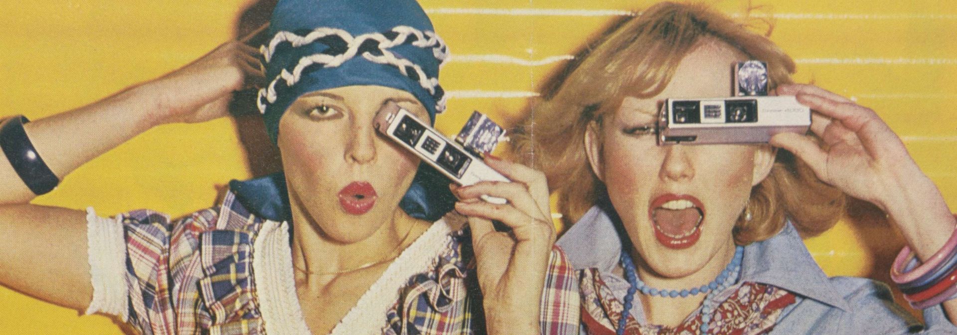 Werbeanzeige aus dem Loeb Katalog. Zwei Frauen gucken enthusiastisch durch eine Fotoapparat.