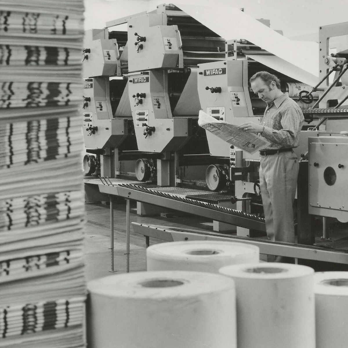 Mann vor einer Offsetdruckmaschine stehend.